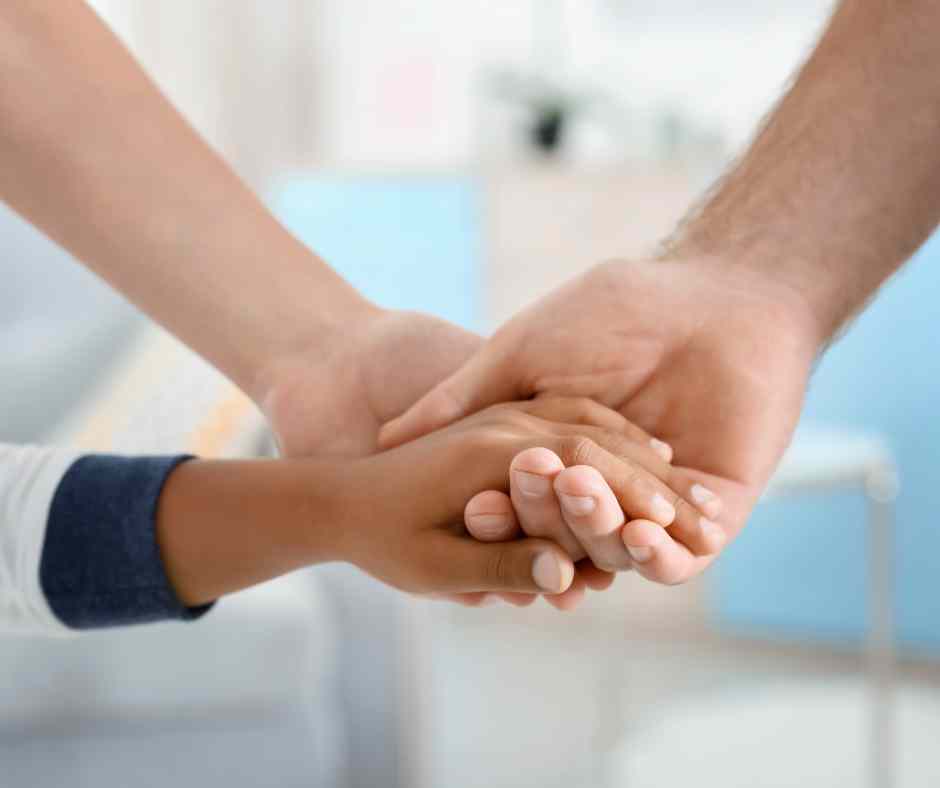 Due mani che stringono la mano di un bambino