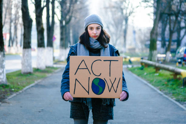 attivista che regge un cartello "act now"
